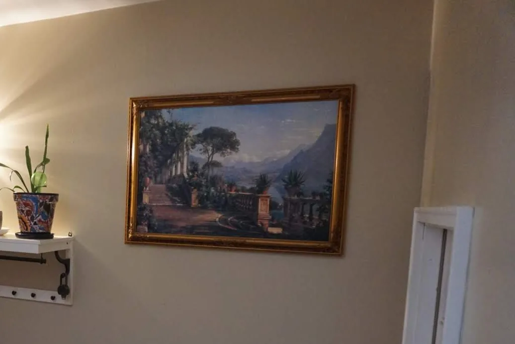 An entry hallway we painted: one even gray wall, the shelf and framed picture back up.